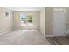 Spacious, carpeted living room with large windows offering ample natural light and hardwood at entry at 1833 Luther St, Indianapolis, IN 46203