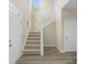 Staircase with carpeted steps, white railing, and hardwood flooring at base at 1833 Luther St, Indianapolis, IN 46203