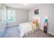 Bright bedroom features a white twin bed, carpeted floors, and ample natural light from the window at 1841 Luther St, Indianapolis, IN 46203