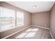 A carpeted bedroom features two windows offering picturesque views of a pond and a charming house at 1902 Zwingley St, Indianapolis, IN 46203