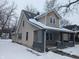 Two-story house with a gabled roof and porch, covered in snow at 3050 N Gladstone Ave, Indianapolis, IN 46218
