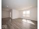 Bright, spacious living room with vinyl flooring, a back door, and a large window at 3201 W Keepsake Ln, Monrovia, IN 46157