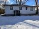 A rear view of a white home with a small utility shed in a snowy backyard at 3951 N Pasadena St, Indianapolis, IN 46226