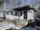 A charming home boasts a covered front porch and fresh white siding, promising cozy curb appeal at 3951 N Pasadena St, Indianapolis, IN 46226
