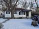 A cozy home with snowy front yard featuring mature trees and black window shutters at 3951 N Pasadena St, Indianapolis, IN 46226