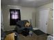 A living room with neutral walls, gray sofa, and a bright white entry door at 3951 N Pasadena St, Indianapolis, IN 46226