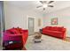 Living room with red couches, hardwood floors, and ceiling fan at 4702 Michigan Rd, Indianapolis, IN 46228