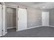 Bedroom with gray walls, gray carpeting, and a white barn door at 4759 Ohio St, Clayton, IN 46118