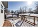 Wooden deck with metal railings, offering views of a residential street and snowy yard at 4759 Ohio St, Clayton, IN 46118