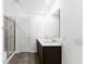 Bathroom with double sink vanity, tiled shower with glass door, and plank flooring at 4767 E Shadowbrook Dr, Camby, IN 46113