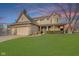 Charming two-story home featuring a brick-accented facade, attached garage, and a well-manicured lawn under a colorful sky at 5230 Berkshire South Blvd, Greenwood, IN 46142