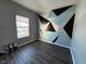 Bedroom with geometric accent wall and wood floors at 6628 Heben Ct, Indianapolis, IN 46113