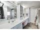 Bright bathroom featuring double sinks, white cabinetry, and a shower with white subway tile at 7129 Dublin Ln, Indianapolis, IN 46239