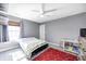 Bedroom with neutral walls and carpet featuring a ceiling fan and a bed with a red rug at 7129 Dublin Ln, Indianapolis, IN 46239