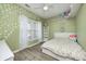 Light and airy bedroom with floral wallpaper accents, shelving, and a ceiling fan at 7129 Dublin Ln, Indianapolis, IN 46239