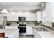 Well-lit kitchen featuring stainless steel appliances, ample counter space, and white cabinetry at 7129 Dublin Ln, Indianapolis, IN 46239