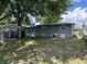 A quaint backyard featuring a covered patio area, grassy space, and mature trees at 835 E Berwyn St, Indianapolis, IN 46203