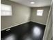 Neutral bedroom with a black hardwood floors, two windows offering natural light, and baseboard trim at 835 E Berwyn St, Indianapolis, IN 46203
