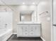 Well-lit bathroom featuring a double sink vanity with modern fixtures and sleek dark wood-look flooring at 943 Aurora Ln, Franklin, IN 46131