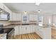 L-shaped kitchen with white cabinets and black appliances at 9791 N Gasburg Rd, Mooresville, IN 46158