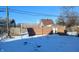 Snowy backyard with a wooden fence and a glimpse of neighboring buildings at 1052 N Mount St, Indianapolis, IN 46222