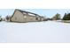 Tan house with backyard covered in snow; view of trees and a mostly clear sky at 11537 Jagged Rock Ct, Fishers, IN 46037