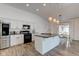 Modern kitchen with white cabinets, stainless steel appliances, granite countertops, and a large island at 15759 Hargray Dr, Noblesville, IN 46062