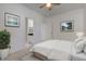 Bright bedroom featuring white walls, ceiling fan, ensuite bathroom, and decorative artwork for a serene and inviting atmosphere at 15759 Hargray Dr, Noblesville, IN 46062