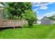 Backyard with a wooden deck, lush green lawn, and a detached garage at 207 E Ohio St, Fortville, IN 46040
