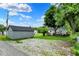 Large backyard featuring multiple sheds, gravel, a deck and mature trees at 207 E Ohio St, Fortville, IN 46040