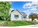 Quaint single-story house with blue shutters, complemented by a beautiful lawn and landscaping at 207 E Ohio St, Fortville, IN 46040