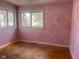 Simple bedroom with hardwood floors and pink walls at 208 Winding Dr, Alexandria, IN 46001
