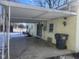 Covered carport with concrete parking area and trash bin at 208 Winding Dr, Alexandria, IN 46001