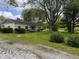 Single-story home with light yellow siding and an expansive lawn with mature trees at 208 Winding Dr, Alexandria, IN 46001