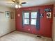 Cozy bedroom with red walls, double window, and ceiling fan at 245 Myerwood Dr, Danville, IN 46122