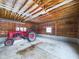 Spacious garage interior with a vintage tractor and wooden beams at 2584 W Mercer Ln, Pendleton, IN 46064