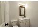 Simple bathroom with white vanity, brown framed mirror, and updated light fixture at 3459 Lauren Dr, Indianapolis, IN 46235