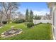 Well-maintained backyard with mature trees, lush lawn, manicured landscaping, and privacy fence at 3543 Clearwater Cir, Indianapolis, IN 46240