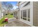 Spacious backyard patio featuring lots of light with a red bench and screened in door at 3543 Clearwater Cir, Indianapolis, IN 46240