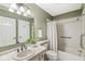Neutral-toned bathroom featuring a shower/tub combo, white tile, and matching-colored countertop and sink at 3543 Clearwater Cir, Indianapolis, IN 46240