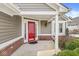 Inviting front porch with a red door, classic black lantern, and charming landscaping, creating a warm welcome at 3543 Clearwater Cir, Indianapolis, IN 46240