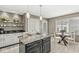 Bright eat-in kitchen features granite island, pendant lights and glass shelving for storage and display at 3543 Clearwater Cir, Indianapolis, IN 46240