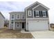 Charming two-story home showcasing a two-car garage and appealing gray siding at 3945 Highcrest Rd, Indianapolis, IN 46239