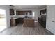 Spacious kitchen with stainless steel appliances, central island, and wood grain flooring at 3945 Highcrest Rd, Indianapolis, IN 46239