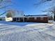 Ranch house with covered porch and snowy front yard at 407 Hawthorne Ln, Greenfield, IN 46140