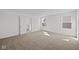 Bedroom with carpet flooring, white walls, two windows, and a walk-in closet at 5144 Rolling Meadow Blvd, Indianapolis, IN 46237