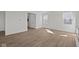 Bright living room with modern flooring, white walls, and views of staircase and front entrance at 5144 Rolling Meadow Blvd, Indianapolis, IN 46237