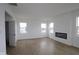 Bright living room with wood-look floors, an electric fireplace, and several windows at 5144 Rolling Meadow Blvd, Indianapolis, IN 46237