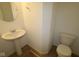 A well-lit powder room has a pedestal sink, a round mirror, and a standard toilet at 5144 Rolling Meadow Blvd, Indianapolis, IN 46237