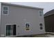 Rear view of a two-story home with gray siding, multiple windows and sliding glass door at 5147 Rolling Meadow Blvd, Indianapolis, IN 46237